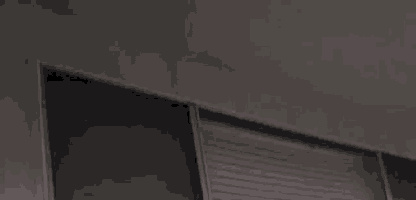 a close up of a sliding door in a dark room with a ceiling in the background .