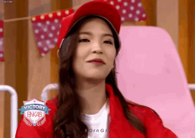 a woman wearing a red hat and a red jacket with the word victory on it .