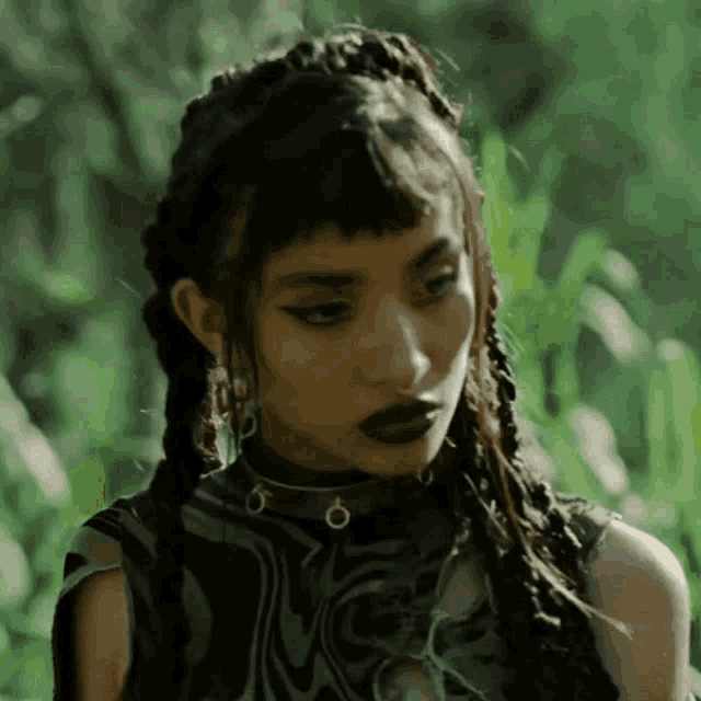 a close up of a woman with braids and a choker