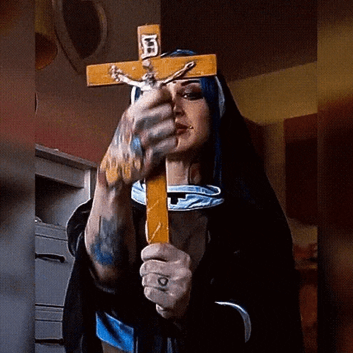 a woman in a nun costume is holding a cross with the letter f on it