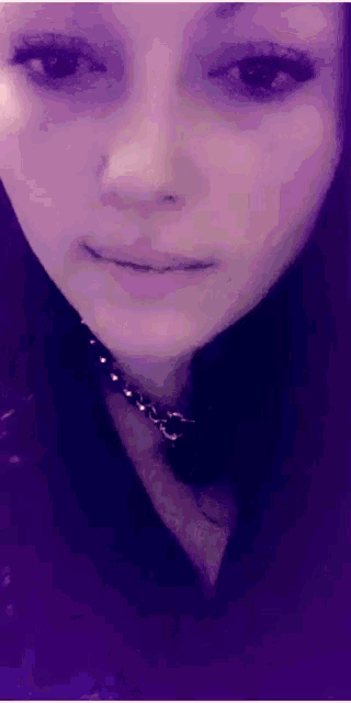 a close up of a woman 's face wearing a choker