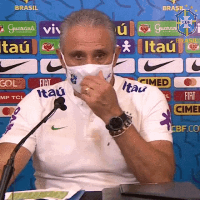 a man wearing a face mask with itau written on his shirt