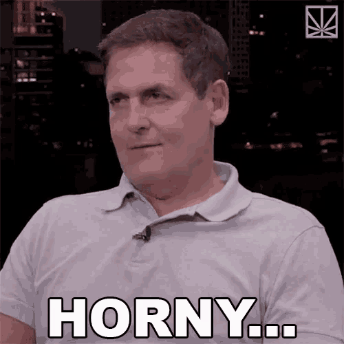 a man in a gray shirt says horny in white letters