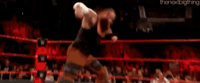 a wrestler is kneeling down in a wrestling ring .
