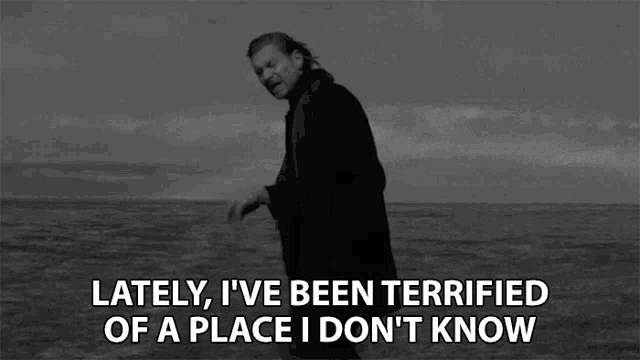 a black and white photo of a man walking on the beach with the caption lately i 've been terrified
