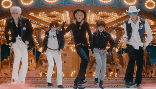 a group of young men dancing in front of a merry go round