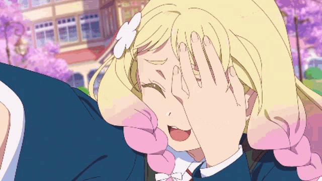 a girl with blonde hair covering her face with her hands