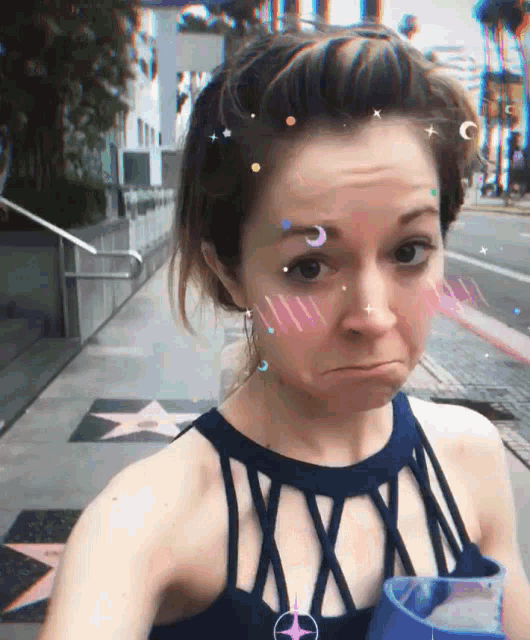 a woman wearing a blue tank top with a star in the background