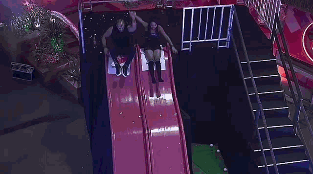 a group of people are playing on a slide in a playground