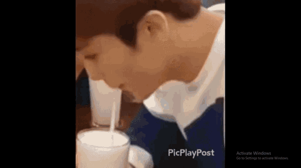 a man is drinking a milkshake with a straw .