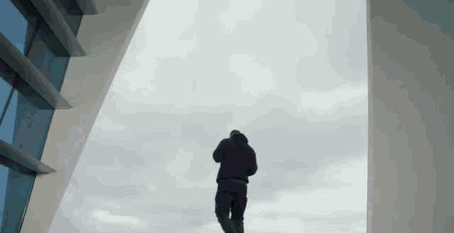 a man in a black jacket is standing in the middle of a building