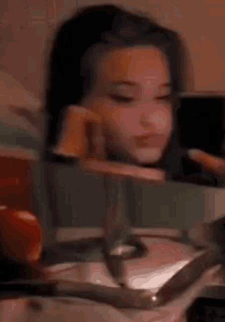 a girl is looking at herself in the mirror while sitting at a table .