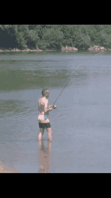 a man is fishing in a lake with a fishing rod