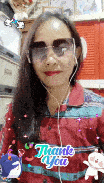 a woman wearing sunglasses and ear buds with a thank you sticker on her shirt
