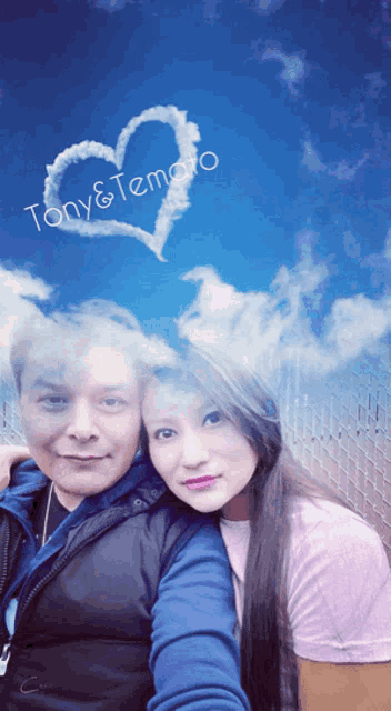 a man and a woman are posing for a picture with a heart drawn in the sky above them that says tony & temaro