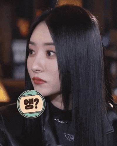 a woman with long black hair has a sticker on her neck that says ' e ' on it