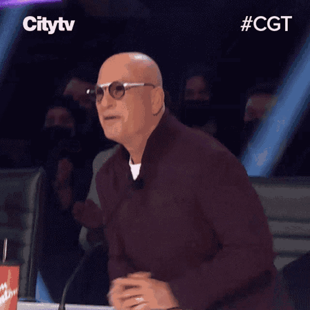a bald man wearing sunglasses is sitting in front of a microphone with the hashtag #cgt on the bottom left