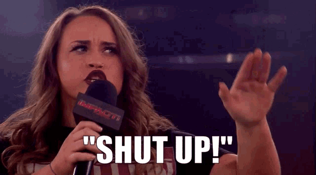 a woman speaking into a microphone that says impact