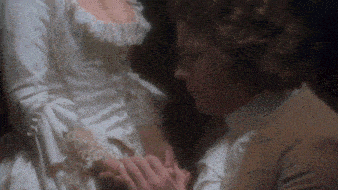 a man and woman holding hands in a dark room