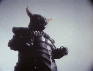 a statue of a monster with horns is standing in front of a white background