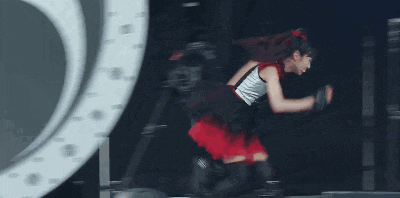a man playing a guitar and a woman in a red skirt are on a stage