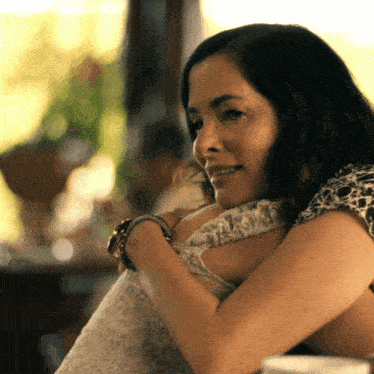 a woman in a white dress is hugging another woman in a black and white shirt