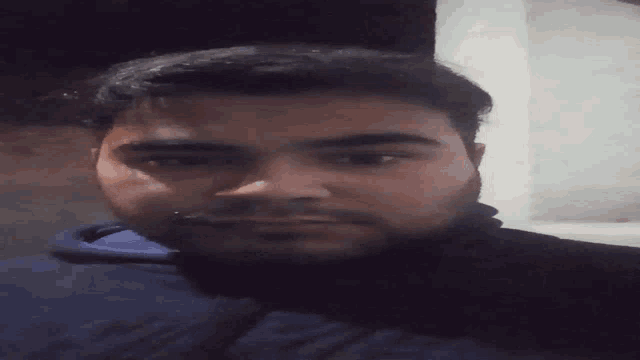 a man with a beard is looking at the camera