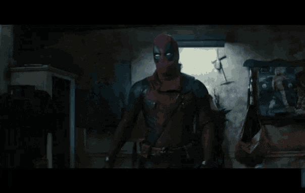 a man in a deadpool costume is standing in a room