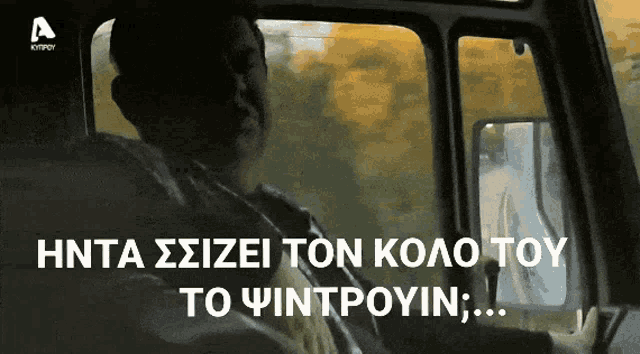 a man is driving a car with a foreign language written on the screen