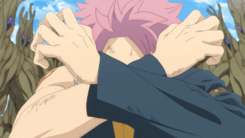 a person with pink hair covering their face with their arms