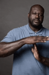 a man in a blue shirt is making a stop gesture with his hands