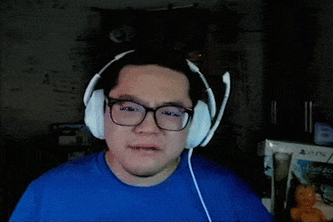 a man wearing headphones and a blue shirt is making a face