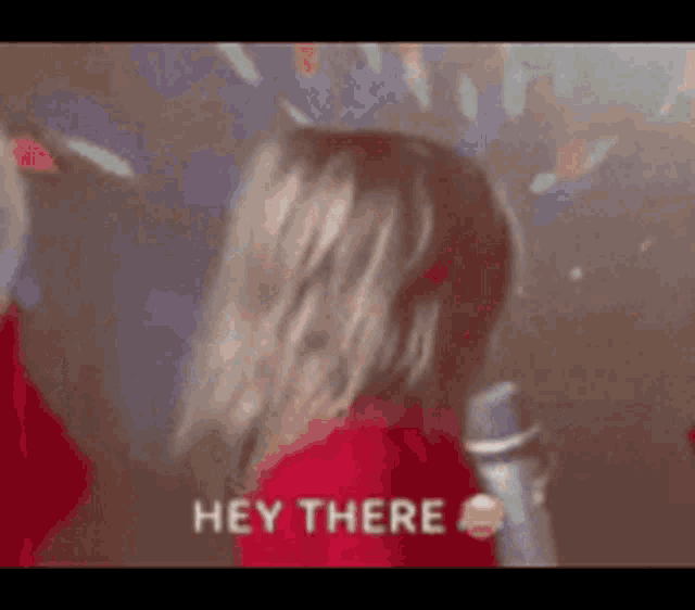 a woman in a red shirt says hey there