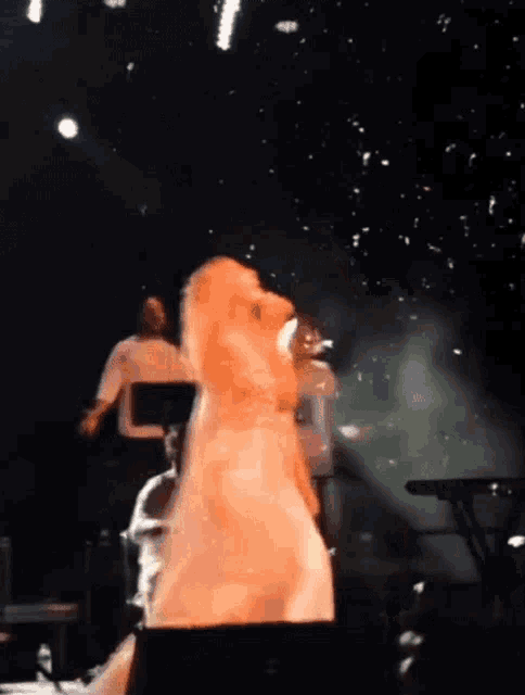 a woman in a white dress is standing on a stage