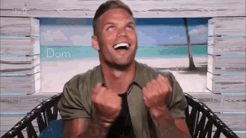 a man is sitting in a chair with his arms in the air and laughing .