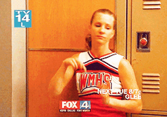 a cheerleader wearing a wmhs uniform is standing in front of a locker