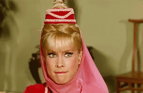 a woman wearing a pink veil and a red hat is making a face .