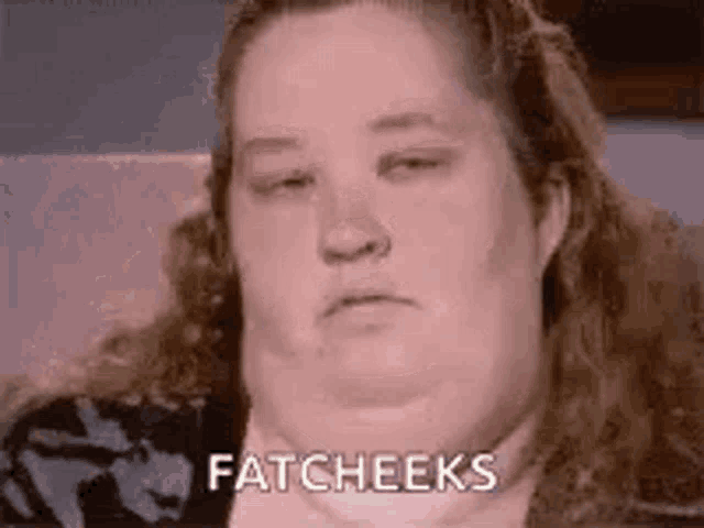 a woman with a big chin is sitting on a couch with her eyes closed and says fatcheeks .