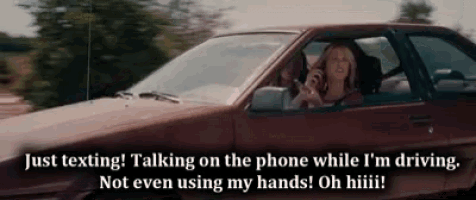 a woman is driving a car and talking on a phone