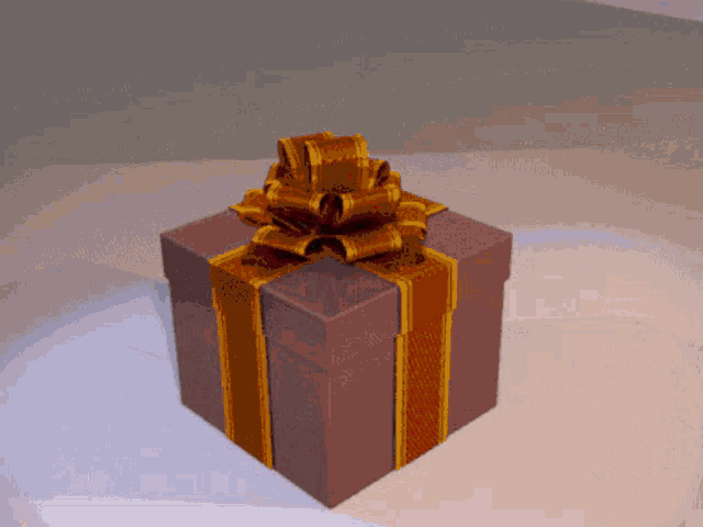 a gift box with a gold bow on top