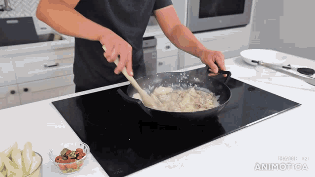 a man is stirring a frying pan with a wooden spoon and the words made in animatica are on the bottom of the screen