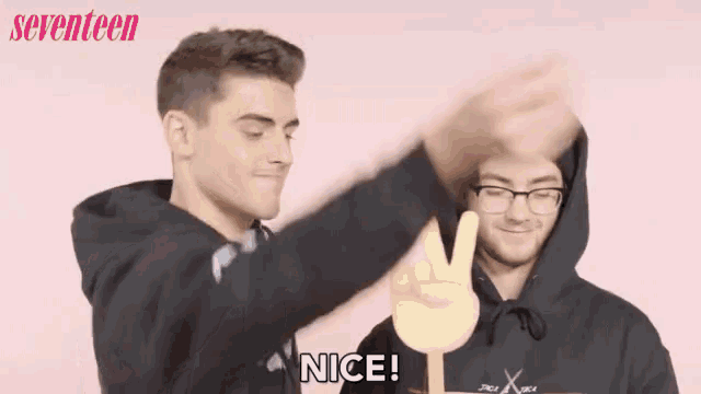 a man wearing a black adidas hoodie is giving a high five to another man