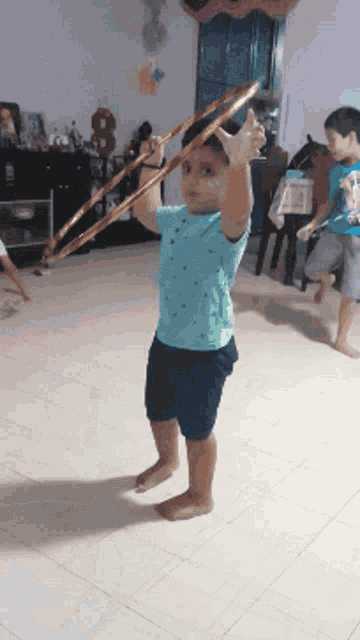 a young boy in a blue shirt is holding a hula hoop in his hands