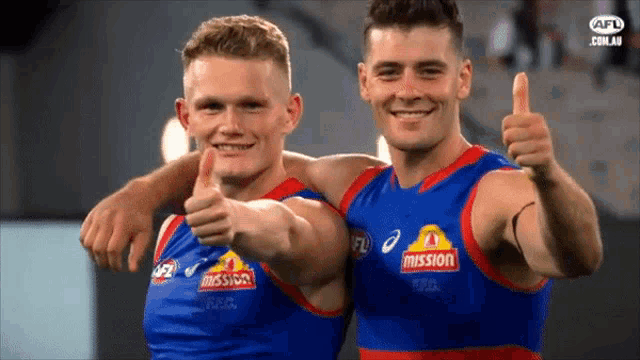 two athletes giving a thumbs up with mission written on their shirts