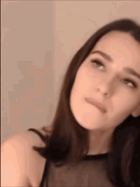 a close up of a woman 's face with a black top on