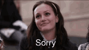 a woman is smiling and saying sorry in a crowd of people .