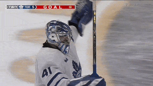 a hockey player with the number 41 on his jersey holds his glove up in the air