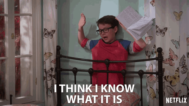 a boy is holding a book and says i think i know what it is on the bottom