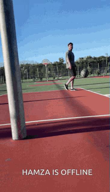 a man playing basketball on a red court with hamza is offline written below him