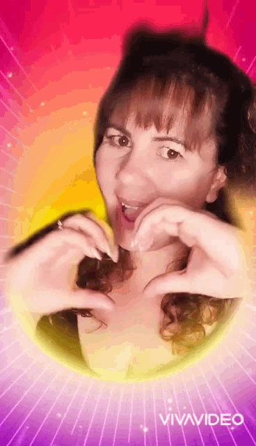 a woman is making a heart with her hands on a pink and purple background .